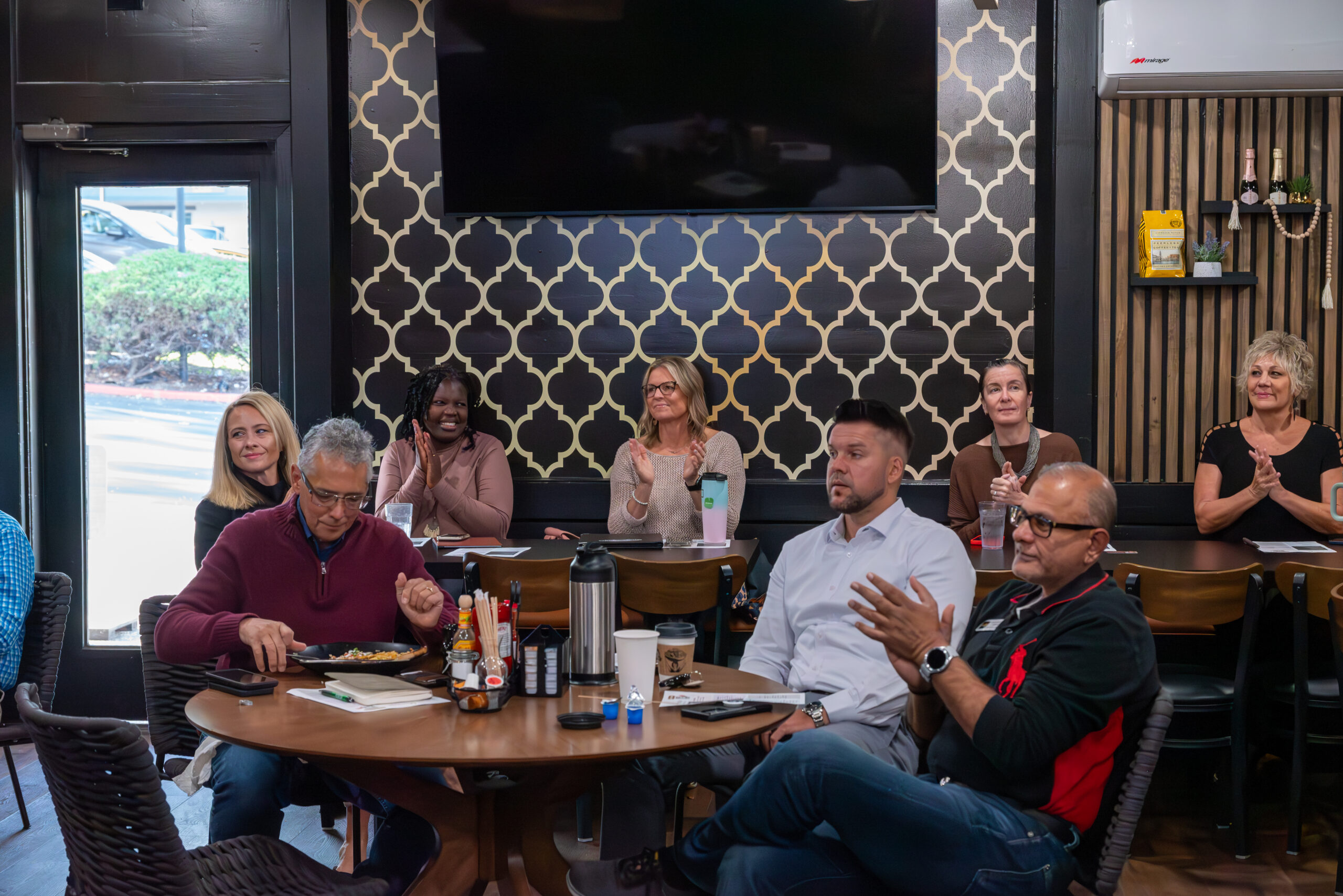 TCBE members applauding during a weekly meeting